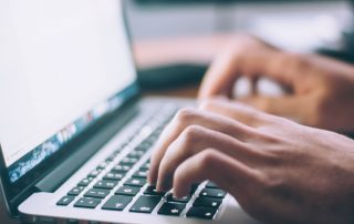 hands typing on a keyboard