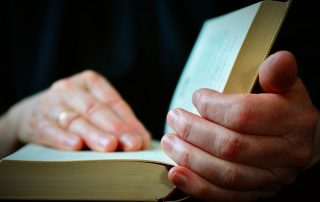 Hands on an open Bible