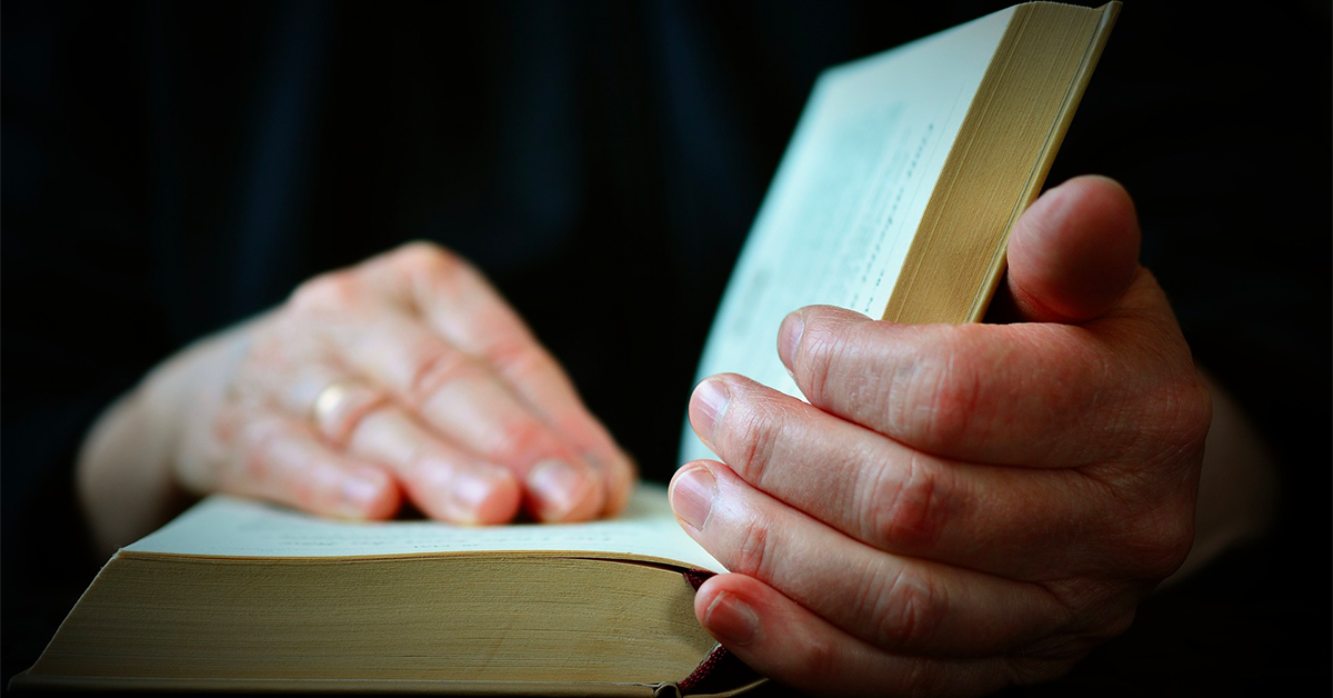 Hands on an open Bible