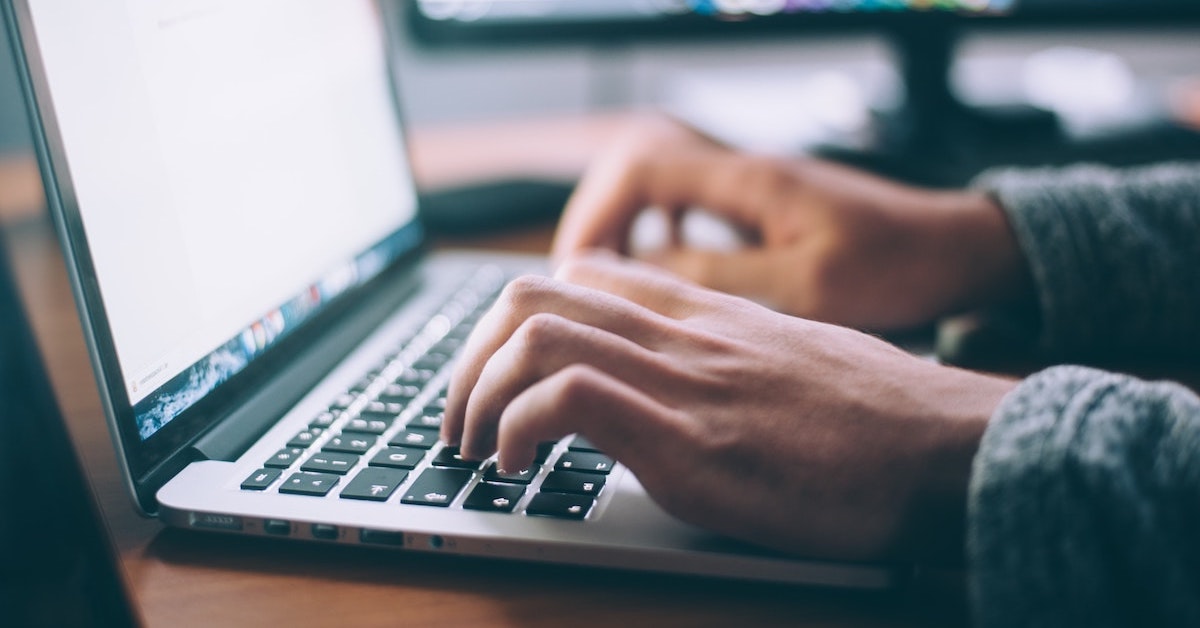 Hands typing on laptop computer