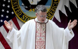 Arch Bishop of Military Services Timothy Broglio in Arch Bishop robes with hands raised in prayer