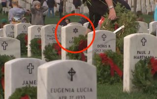 Photo of Wreaths Across America volunteer placing a wreath on a grave marked with the Star of David