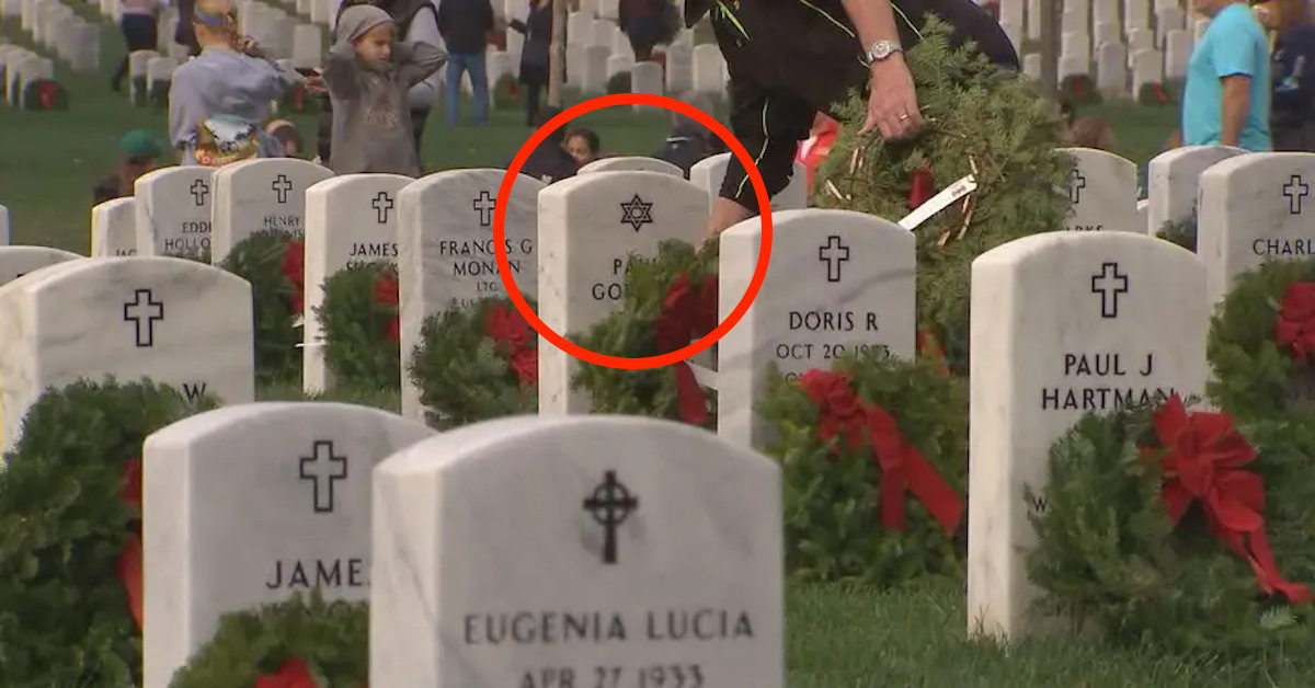 Photo of Wreaths Across America volunteer placing a wreath on a grave marked with the Star of David