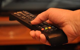 Hand holding TV remote