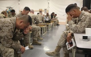 Military service members in prayer.