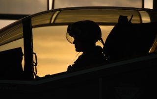 Silhouette of fighter pilot in plane cockpit