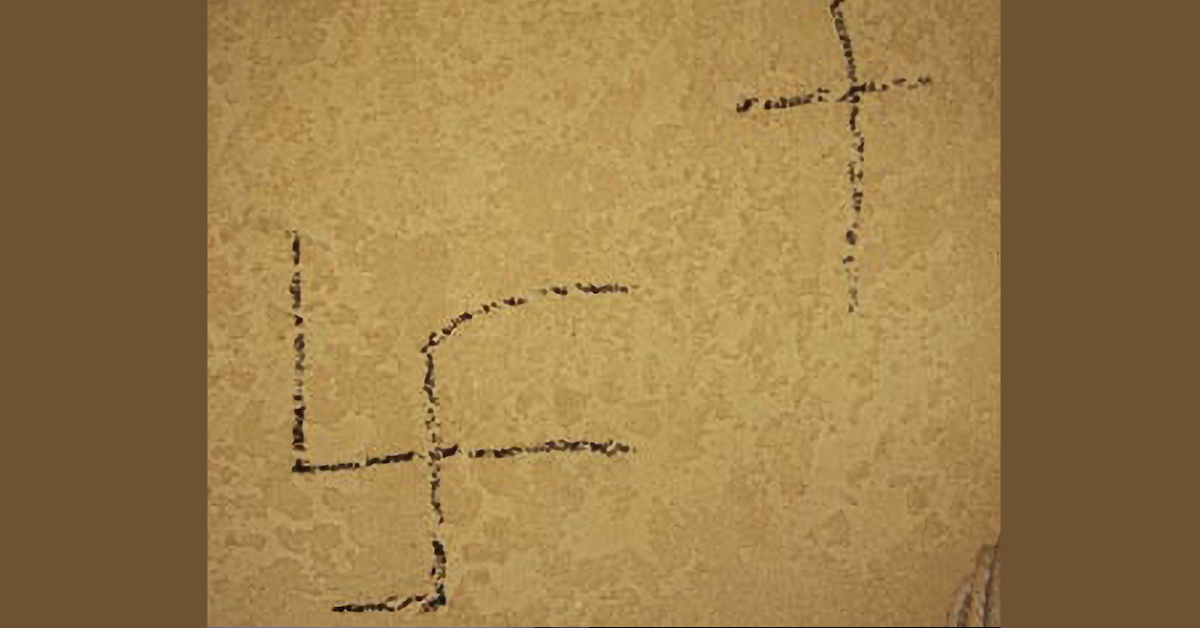 Swastika and cross scrawled on wall