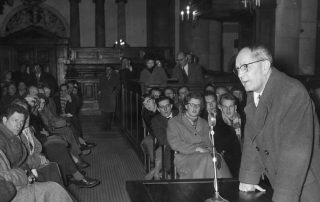 Black and white photograph of Christian Minister Martin Niemöller speaking to a group of people.