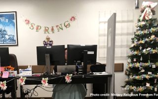 Audie Murphy VA medical center lobby with people at computer stations with He is risen sign behind them and Easter tree next to them