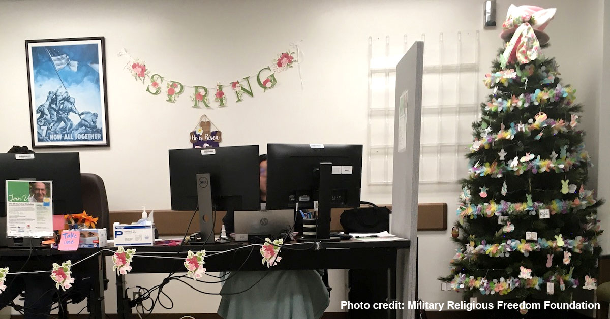 Audie Murphy VA medical center lobby with people at computer stations with He is risen sign behind them and Easter tree next to them