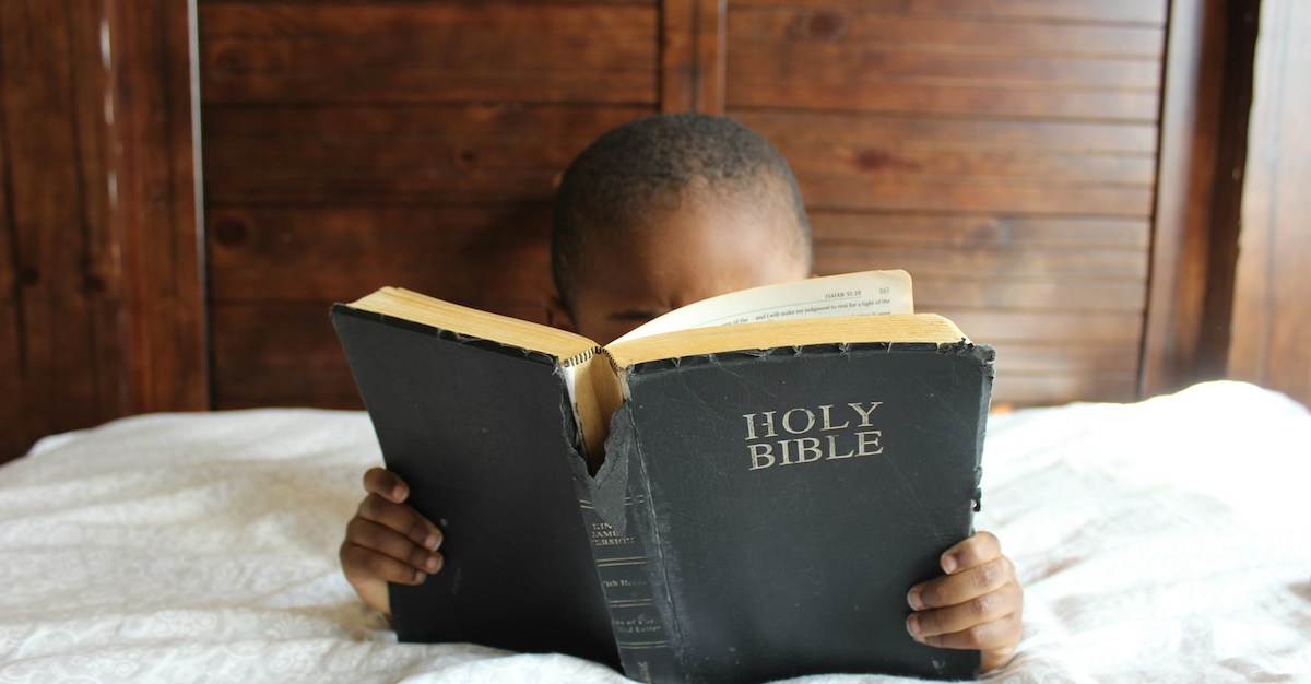 kid-bible Small child reading bible that's bigger than they are