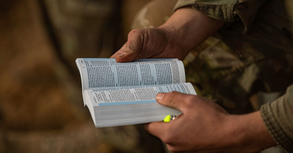 soldier's hands holding bible