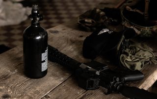Assault rifle and other military items on wood shelf