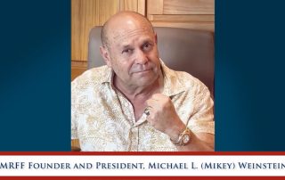 Mikey Weinstein Video Thumbnail with fist held up and a determined smile 6-16-25