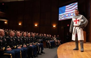 Hegseth in front of a military audience in a crusader uniform
