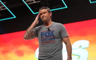 Pete Hegseth on stage wearing Fox News t-shirt